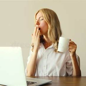 Woman with sleep apnea fatigue yawing at computer